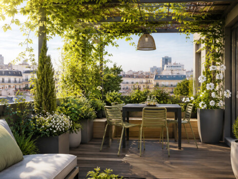Aménagement d’une petite terrasse rooftop avec pergola végétale, coin repas, bacs design et plantes grimpantes pour ombrage naturel.