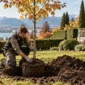 Paysagiste plantant un jeune arbre dans un jardin à Genève en automne